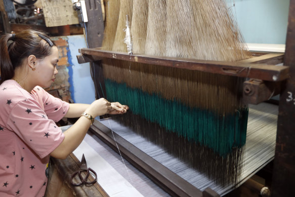 Working a silk loom at a traditional silk factory in Tan Chau.