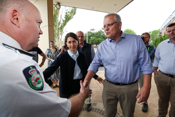 Prime Minister Scott Morrison and NSW Premier Gladys Berejiklian with RFS Commissioner Shane Fitzsimmons at the Picton Bowling Club, which was being used as a evacuation centre in December.
