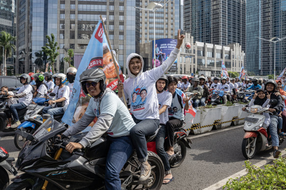 A convoy of supporters of Defence Minister Prabowo Subianto poses for photos on the way to the quick count.