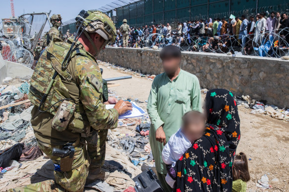Major Tim Glover, part of the 1st Battalion, Royal Australian Regiment, assists the Department of Foreign Affairs and Trade with locating Afghan Australian visa holders at the congested Abbey Gate at Hamid Karzai International Airport, later the scene of a deadly Islamic State attack.