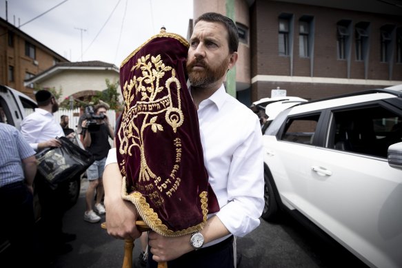 Chaim Klein carries a Torah scroll from Adass Israel synagogue on Friday afternoon.