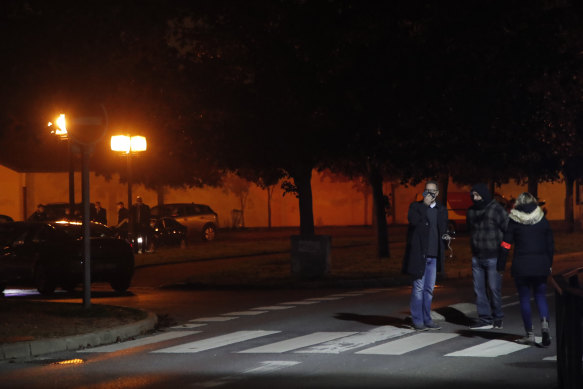 French police officers gather at the scene of the teacher's death in Conflans Sainte-Honorine.