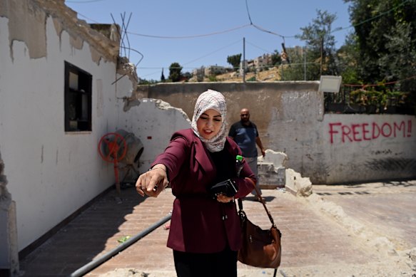 Amani Mousa Odeh points to what used to be the kitchen of her partially demolished home.