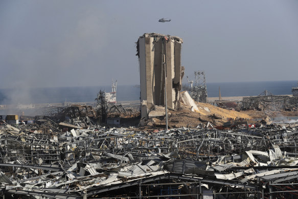 A Lebanese army helicopter flies over the scene of the explosion in Beirut.