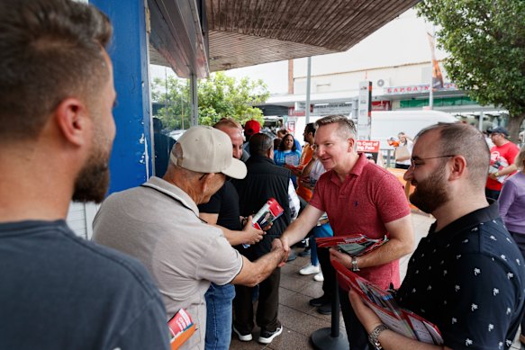 Climate Change and Energy Minister Chris Bowen, the incumbent MP for McMahon, hands out how-to-vote cards.