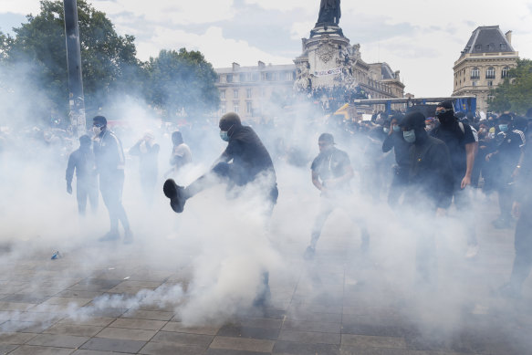 A man kicks a tear gas canister during a march against police brutality and racism in Paris on Saturday, June 13.