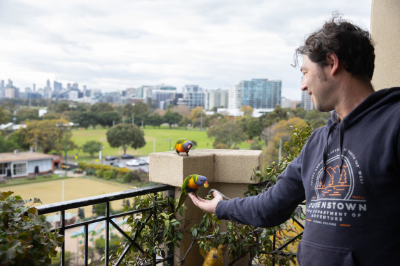 Marcello Callmistro gets a visit from some lorikeets on his balcony in St Kilda. 