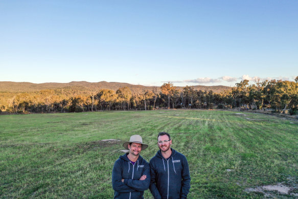 Nick Clark, right, and husband Brett Hadlow stand in the field they are planning to plant vines in.