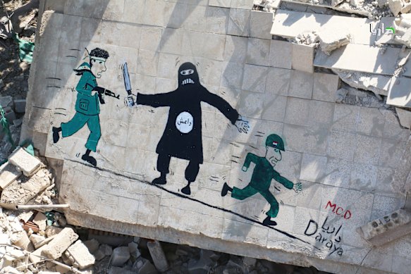 Un murale nella città siriana di Daraya mostra i ribelli (a sinistra) che devono affrontare i militanti dello Stato Islamico (al centro) mentre le forze governative fuggono (a destra). Il caos della guerra civile in Siria ha consentito l’ascesa dell’IS lì e nel vicino Iraq. 