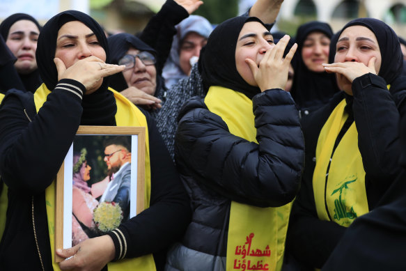 Mourners at a funeral in Lebanon with a photograph believed to be of Australian man Ibrahim Bazzi and his wife Shorouq Hammoud.