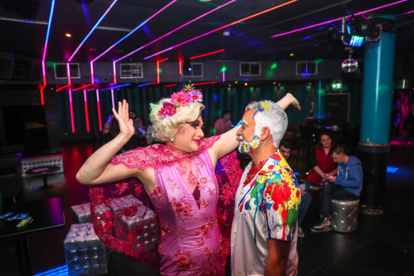 Drag queen Charisma Belle and Kevin Kaila with patrons inside ARQ.