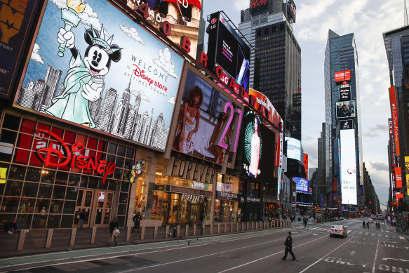 A police officer walks across an empty Seventh Avenue in a sparsely populated Times Square in New York.