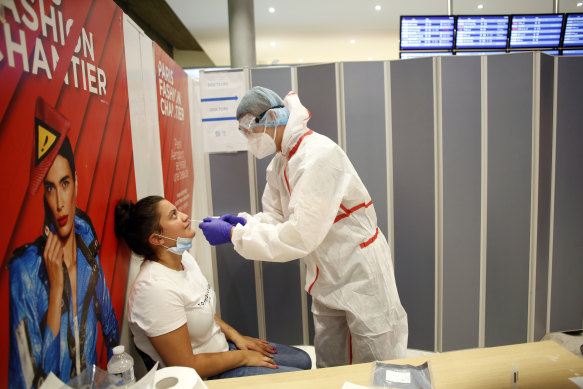 A health worker collects a nasal swab at Roissy Charles de Gaulle airport, outside Paris.