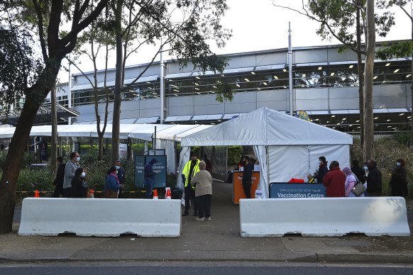 People queue for COVID-19 vaccinations at the NSW Health Vaccination Centre at Sydney Olympic Park.