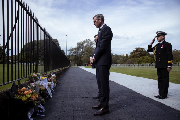 NSW Premier Dominic Perrottet lays flowers at Government House in Sydney on Friday.