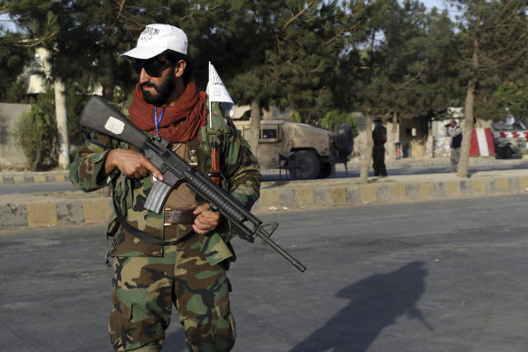 Taliban fighter stand guard at a checkpoint near the gate of Hamid Karzai international Airport in Kabul.