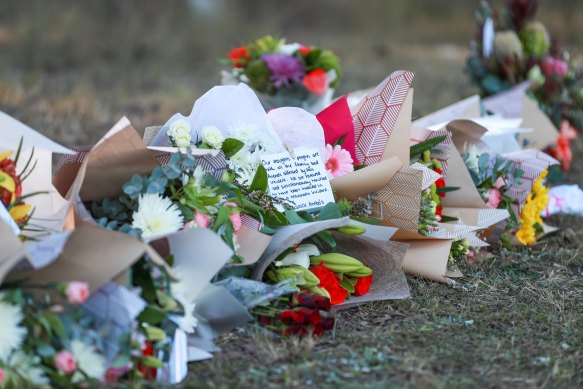 Floral tributes lie next to the road where a horror bus crash claimed 10 lives last Sunday night.