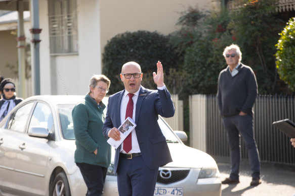 As auctioneers work the crowd, buyers are cautious to raise their hands.