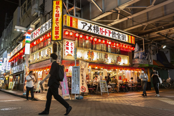 Bottoms up, Japan. People enjoy drinks and foods at Japanese bar in Ueno area in Tokyo, Japan.