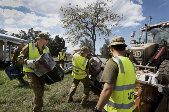 Defence personnel help clear flood-damaged furniture and belongings at Em Trotter’s home in Croki near Taree.