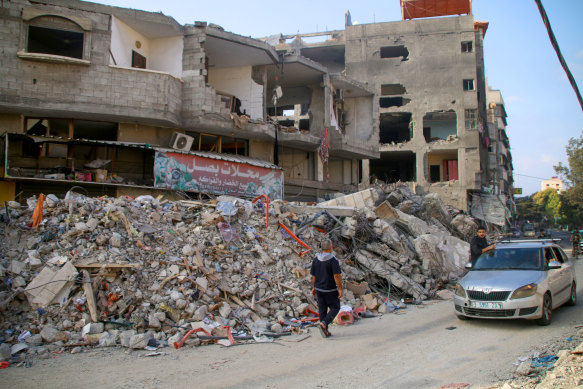 Palestinian citizens inspect damage to their homes caused by Israeli airstrikes.