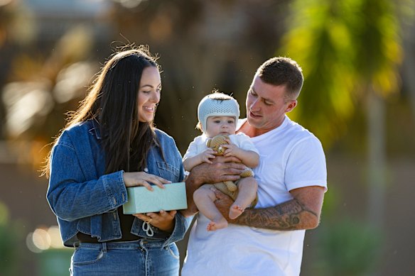 Maddison and Luke Waldron with their son, Kai. The family received an angel box of clothes made by volunteers after Kai’s twin, Teddy, was stillborn. The box Maddison is holding contains Teddy’s ashes. 