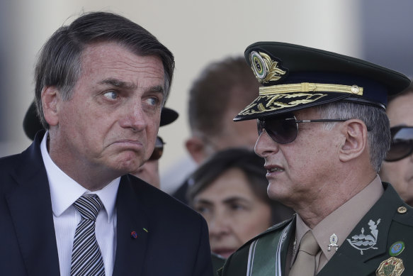 Brazilian President Jair Bolsonaro, left, talks with Army Commander General Edson Leal Pujol, during a military ceremony. Pujol has resigned along with the chiefs of the navy and the air force. The Armed Forces have repeatedly said they would not be drawn into politics.
