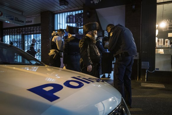 Police take the details of people outside the synagogue on Tuesday. 