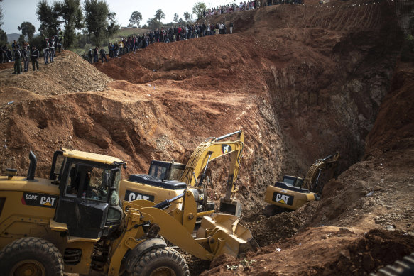Tractors dig through a mountain as they take part in the rescue mission.