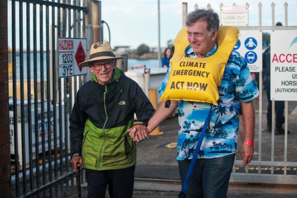 Reverend Alan Stuart (left) walks out the Port Authority of NSW after being arrested by police among the other protestors for blockading the Newcastle port coal channel. 
