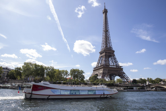 An empty boat travels the river Seine during the technical test event for the Paris 2024 opening ceremony with the Eiffel Tower in the background.