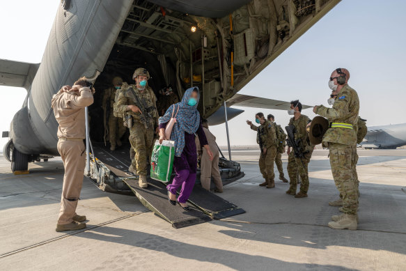 Afghanistan evacuees and Australian soldiers disembark a Royal Australian Air Force C-130J Hercules aircraft at Australia’s main operating base in the Middle East, after their flight from Kabul.