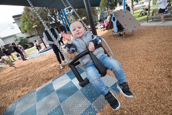 Two-year-old Alexander Warner enjoys the swings at Fels Park in Yarraville,
