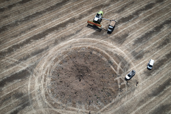 A farmer collects harvest on a field around a crater left by a Russian rocket 10km from the front line in the Dnipropetrovsk region, Ukraine, on July 4.