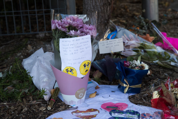Tributes are left outside Newmarch House aged care facility, where 16 people have died with coronavirus. 