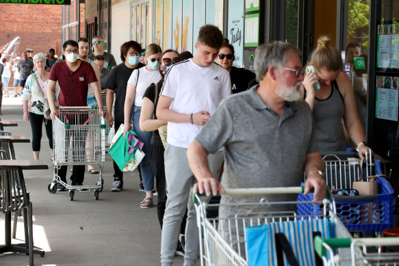 Shoppers queue at an Adelaide Woolworths after the announcement on Wednesday.