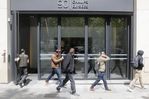 Four police officers, from the right, leave the building hosting McKinsey & Company France on May 24, 2022 in Paris. 