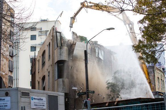 Demolition crews have been working to pull down the two highest walls of a Surry Hills warehouse that was destroyed by fire. 