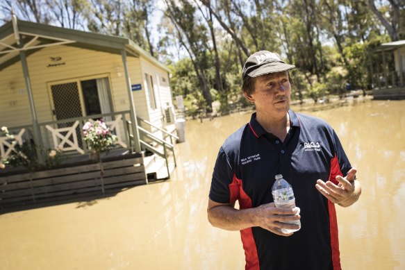 Goulburn River Caravan Park manager Matt Borrack walks through the flooded site on Tuesday.