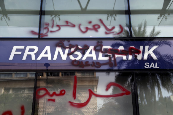 Graffiti accusing the bank of being thieves is written across a shop facade in Beirut, Lebanon. Government restrictions have severely limited bank withdrawals since 2019.