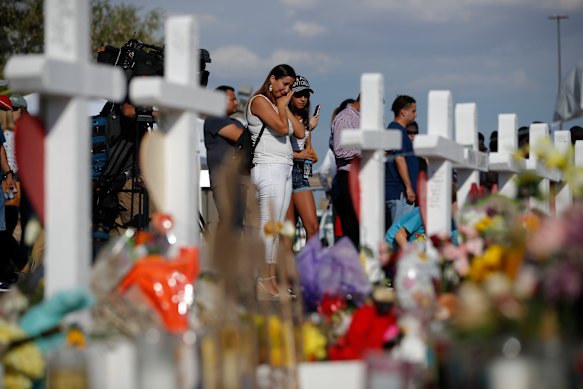 People visit a makeshift memorial at the site of a mass shooting at a shopping complex, in El Paso in August.