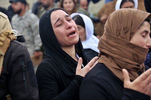 Iraqi Yazidi women mourn during the exhumation of a mass grave in Iraq's north-western region of Sinjar.