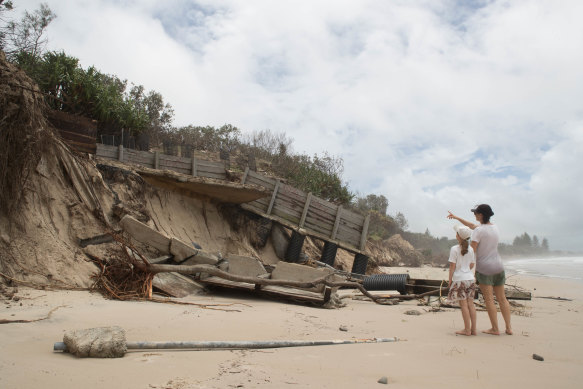 Holidaymakers Kathy Fulton and her eight-year old daughter Beatrice, from Brisbane's Paddington, survey some of the damage at Byron Bay's Main Beach on Tuesday.