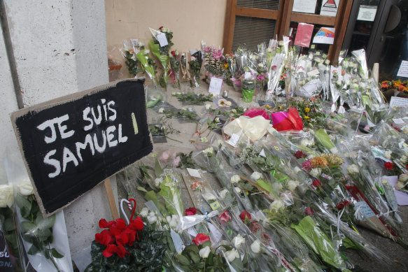 A placard reading "I am Samuel" and flowers lay outside the school where slain history teacher Samuel Paty was working, in Conflans-Sainte-Honorine, north-west of Paris. 