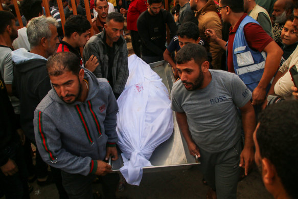 People mourn as they carry the body of a young Palestinian man on Sunday.