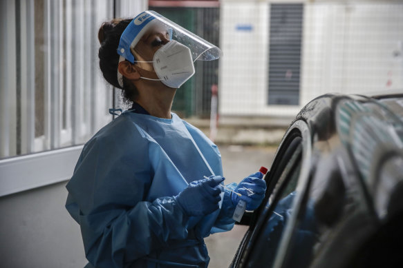 A paramedic works at a COVID-19 drive-through testing site at San Paolo Hospital in Milan.