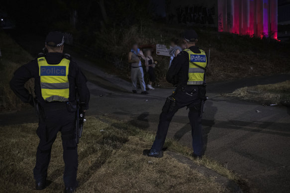 Police gather outside the rave as some leave the event.