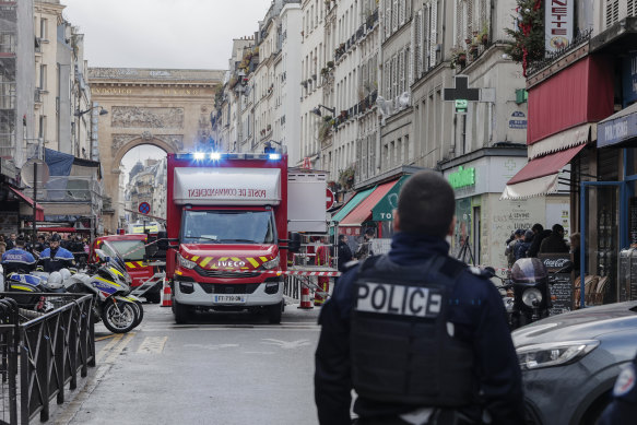 A police officer stands next to the cordoned off area where the shooting took place in Paris.
