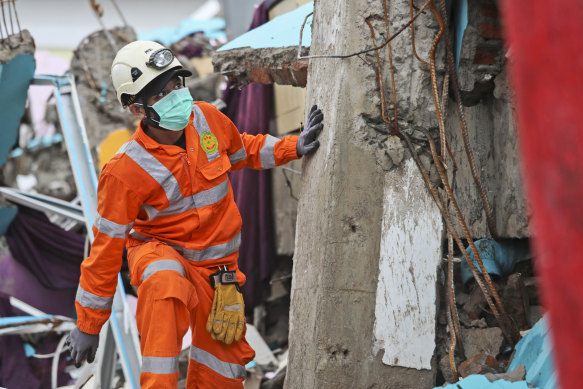 A rescuer inspects the ruin of a building flattened by an earthquake during a search for victims in Mamuju, West Sulawesi, Indonesia, on Sunday.