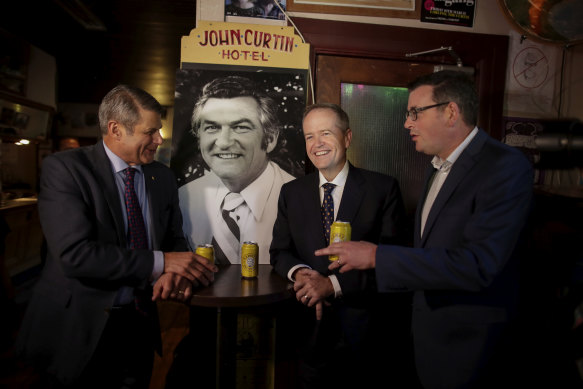 Former premier Steve Bracks, then-opposition leader Bill Shorten and Premier Daniel Andrews share a beer in memory of former Prime Minister Bob Hawke at The Curtin.